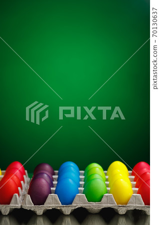 Easter festive multicolor eggs carton, green background 70130637