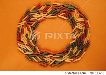 Frame made of colorful green, yellow and red penne pasta naturally coloured with tomato and spinach. 70131320
