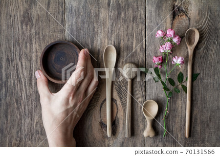 Top view few wooden spoons and rose branch on wooden table, eco-friendly concept of cutlery 70131566