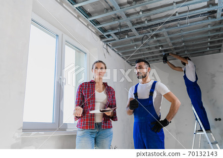 The client checks the work of the workers in the apartment and writes a note The client checks the work of the workers in the apartment and writes a note 70132143