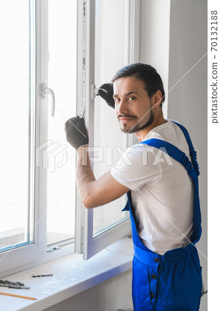 Window-maker installs a window in the room Window-maker installs a window in the room 70132188