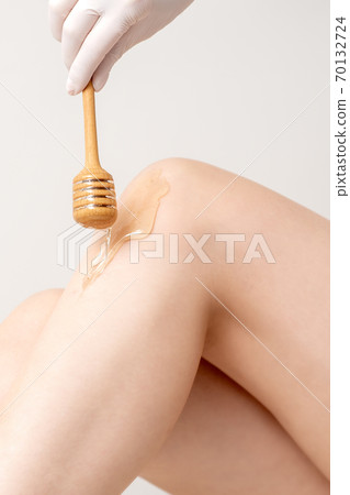 Wax flowing down on female leg 70132724