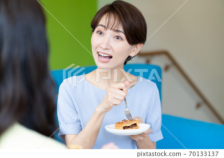 一個女人在沙發上吃蛋糕時說話的特寫 70133137