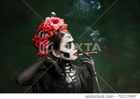 Young girl in the image of Santa Muerte, Saint death or Sugar skull with bright make-up. Portrait isolated on studio background. 70133997