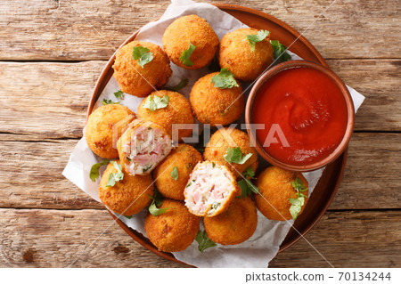 Hot fried sauerkraut balls with ham and cheese close-up in a plate. horizontal top view 70134244