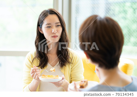 Up of a woman talking over a cup of tea on the sofa 70134345