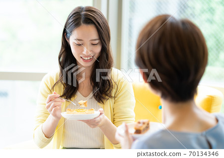 Up of a woman talking over a cup of tea on the sofa 70134346