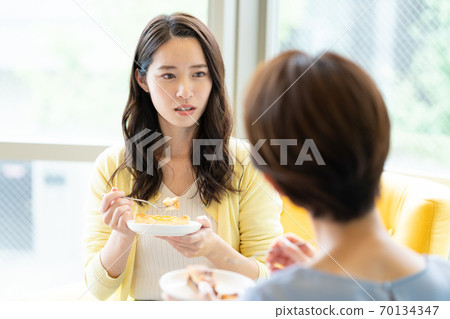 Up of a woman talking over a cup of tea on the sofa 70134347