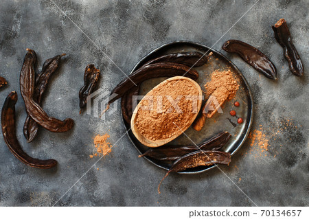 Dry carob pods and powder top view Dry carob pods and powder top view 70134657