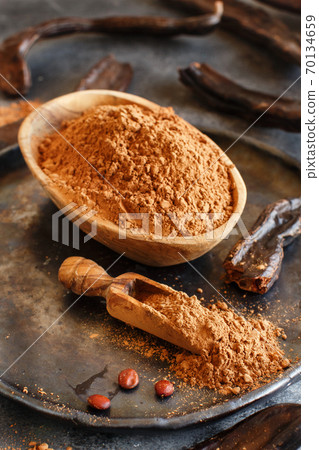 Dry carob pods and powder close up Dry carob pods and powder close up 70134659