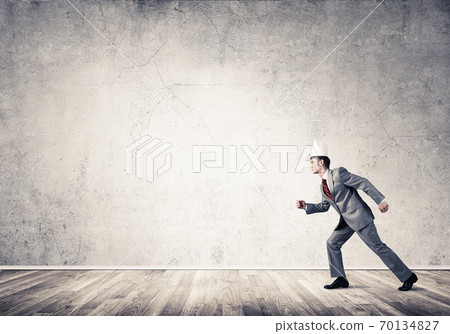 King businessman in elegant suit running in empty room 70134827