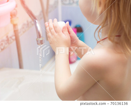 A child washes his hands with soap in the bathroom. The concept of hygiene and clean hands, infection, close-up, soundness A child washes his hands with soap in the bathroom. The concept of hygiene and clean hands, infection, close-up, soundness 70136136