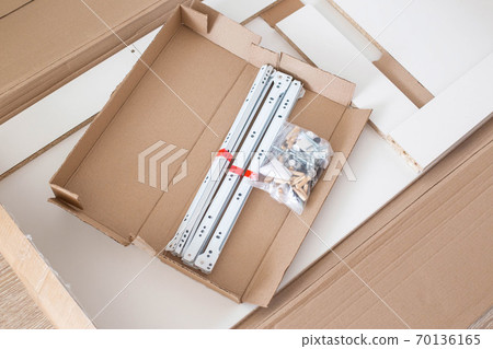 Set of spare parts for assembling modern furniture eccentric couplers and roller guides, box with furniture, background Set of spare parts for assembling modern furniture eccentric couplers and roller guides, box with furniture, background 70136165