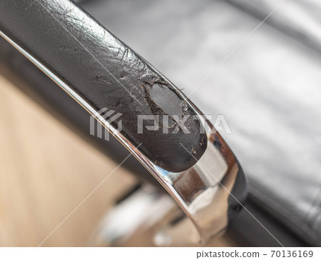 Torn and battered leather on a black office computer chair. Restoration and restoration of the leather, copy space Torn and battered leather on a black office computer chair. Restoration and restoration of the leather, copy space 70136169