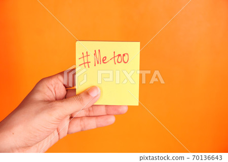 young woman showing a note with the text me too. young woman showing a note with the text me too. 70136643