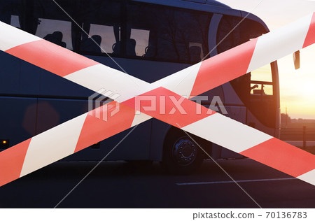Forbidden tape on the background of a travel company passenger bus. The concept of loss and closure of tour operators during the coronavirus pandemic, bankrupt. Closing state borders, traveling Forbidden tape on the background of a travel company passenger bus. The concept of loss and closure of tour operators during the coronavirus pandemic, bankrupt. Closing state borders, traveling 70136783
