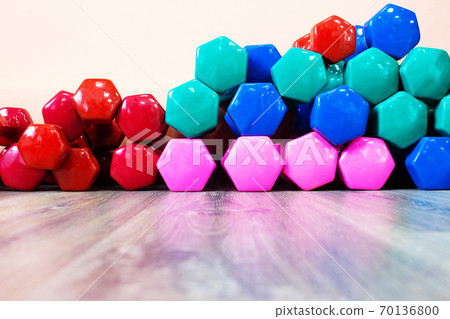 multi-colored dumbbells lie on the floor in the gym, background, copy space 70136800