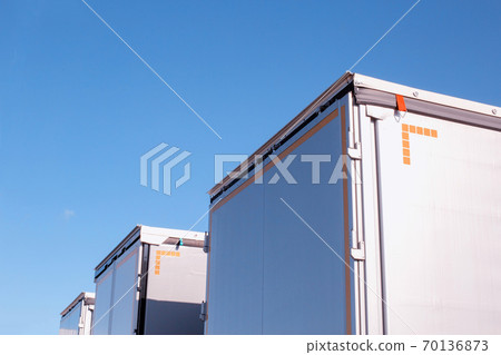 Isotherm cargo semi-trailers on a background of blue sky. The concept of the capacity and volume of a modern semi-trailer in cargo transportation, industry. Copy space for text Isotherm cargo semi-trailers on a background of blue sky. The concept of the capacity and volume of a modern semi-trailer in cargo transportation, industry. Copy space for text 70136873