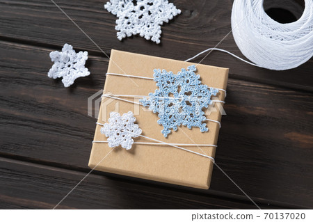Idea gifts wrapping of the Christmas gift and decoration with knitted snowflakes. Idea gifts wrapping of the Christmas gift and decoration with knitted snowflakes. 70137020