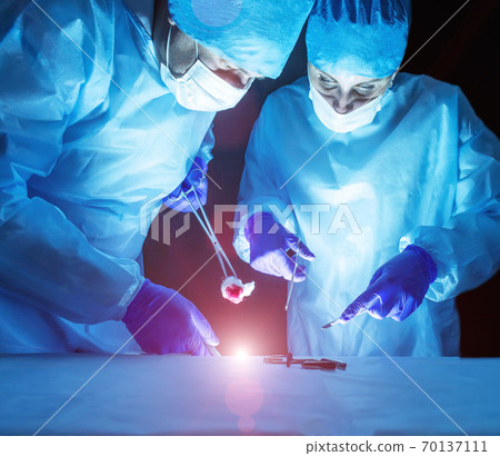 Two doctors perform laser surgery to treat varicose veins and hemorrhoids. Concept laser surgery Two doctors perform laser surgery to treat varicose veins and hemorrhoids. Concept laser surgery 70137111