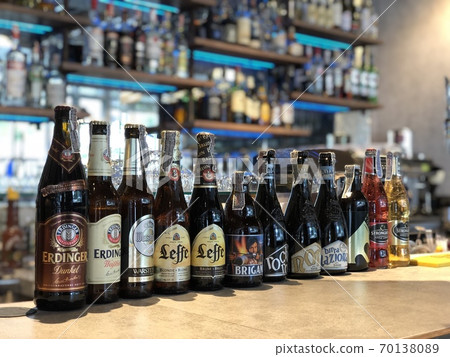 A line of beer bottles on a counter bar. Selective focus. (TRANSLATION: name of each brand). A line of beer bottles on a counter bar. Selective focus. (TRANSLATION: name of each brand). 70138089