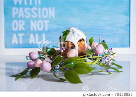 Easter cake in the center of a wreath of spring flowers on a blue vintage background with copy space 70138825