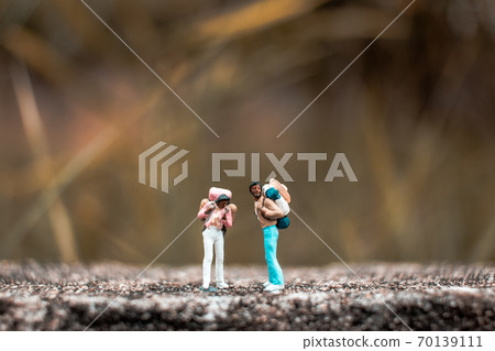 Miniature Backpacker standing on the concrete wall with natural background Miniature Backpacker standing on the concrete wall with natural background 70139111