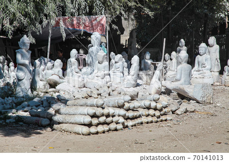 carving Buddha statues from stone in a street workshop in Mandalay, Myanmar 70141013