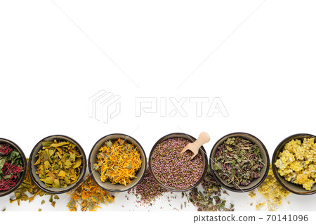 Black bowls of dry medicinal herbs on white background. Top view, flat lay. Alternative medicine. Copy space for text. Black bowls of dry medicinal herbs on white background. Top view, flat lay. Alternative medicine. Copy space for text. 70141096