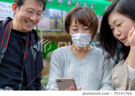 3 people looking at mobile 3 people looking at mobile 70141768