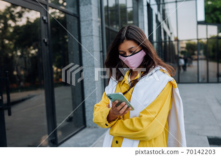 Young woman wearing mask posing on street. Young woman wearing mask posing on street. 70142203