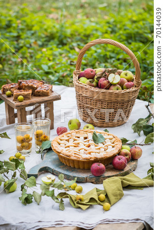 Freshly baked apple pie with stewed fruit glasses and tree branches Freshly baked apple pie with stewed fruit glasses and tree branches 70144039