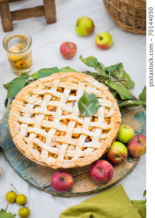 Freshly baked apple pie with stewed fruit glasses and tree branches, top view 70144050