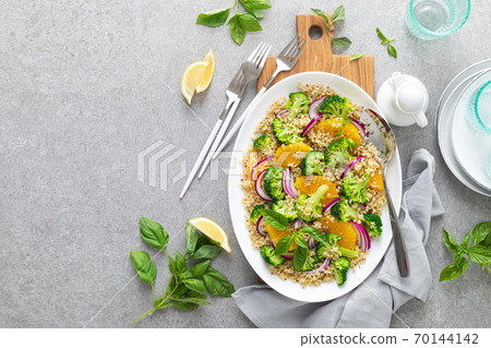 Vegan quinoa and broccoli warm salad with oranges and fresh onion, top down view Vegan quinoa and broccoli warm salad with oranges and fresh onion, top down view 70144142
