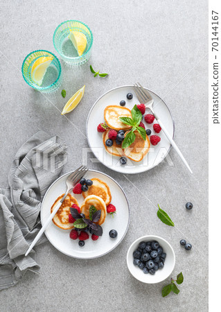 Pancakes with fresh blueberry and raspberry served for healthy vegetarian breakfast 70144167