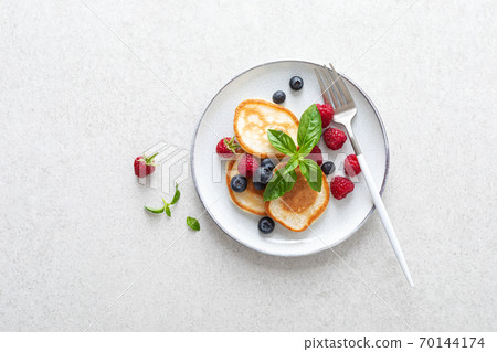 Pancakes with fresh blueberry and raspberry served for healthy vegetarian breakfast 70144174