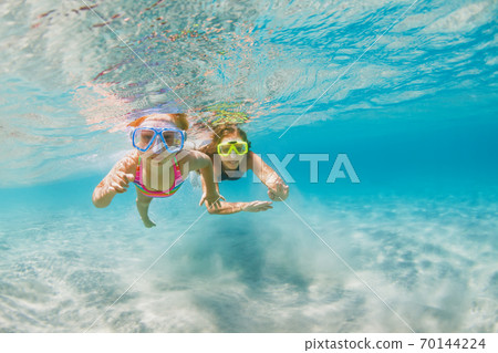 Kids in snorkeling mask dive underwater in blue sea lagoon Kids in snorkeling mask dive underwater in blue sea lagoon 70144224