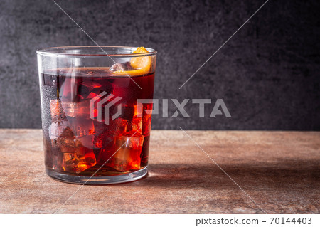 Boulevardier cocktail and orange zest on rusty background.Copy space Boulevardier cocktail and orange zest on rusty background.Copy space 70144403