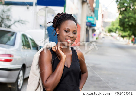 Smiling young woman standing and looking at the camera. 70145041