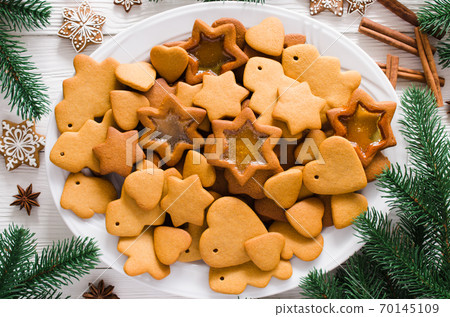 Plate full of freshly baked Christmas gingerbread ready to decorate with icing on white background. Plate full of freshly baked Christmas gingerbread ready to decorate with icing on white background. 70145109