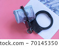 top view handcuffs on an envelope with money, pink background 70145350