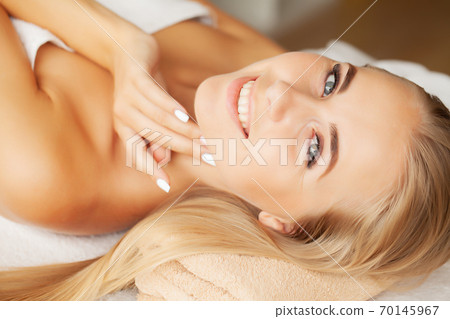 Young woman enjoying of facial massage in spa salon Young woman enjoying of facial massage in spa salon 70145967