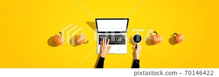 Autumn pumpkins with person using a laptop computer 70146422