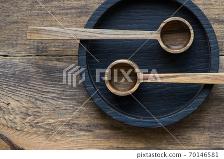 Top view wooden spoons on black plate on wooden table, eco-friendly cutlery concept, selective focus 70146581