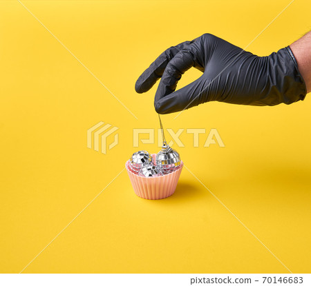 Muffin with disco balls and chef hand in black gloves. Nightlife in retro style.  70146683