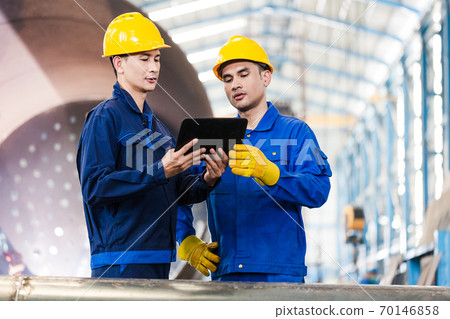 Experts checking information on tablet PC in a modern factory Experts checking information on tablet PC in a modern factory 70146858