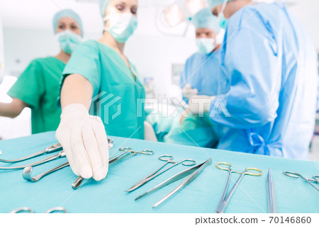 Surgeons operating patient in operating room Surgeons operating patient in operating room 70146860