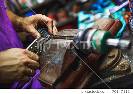 ATV constant-velocity CV joint repair by hands in old garage 70147111