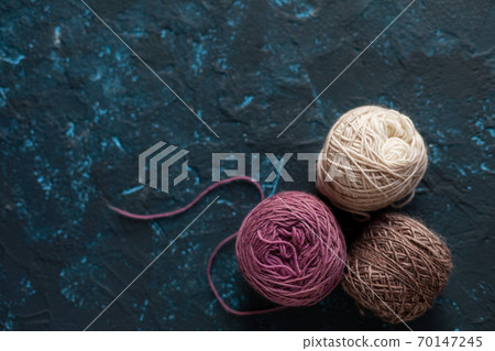 skein of wool yarn for crochet and knit on dark blue texture putty concrete 70147245