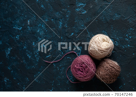 skein of wool yarn for crochet and knit on dark blue texture putty concrete 70147246